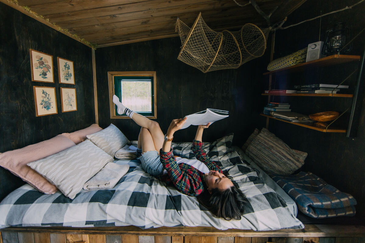 Person reading a book in bed at Uhkua.